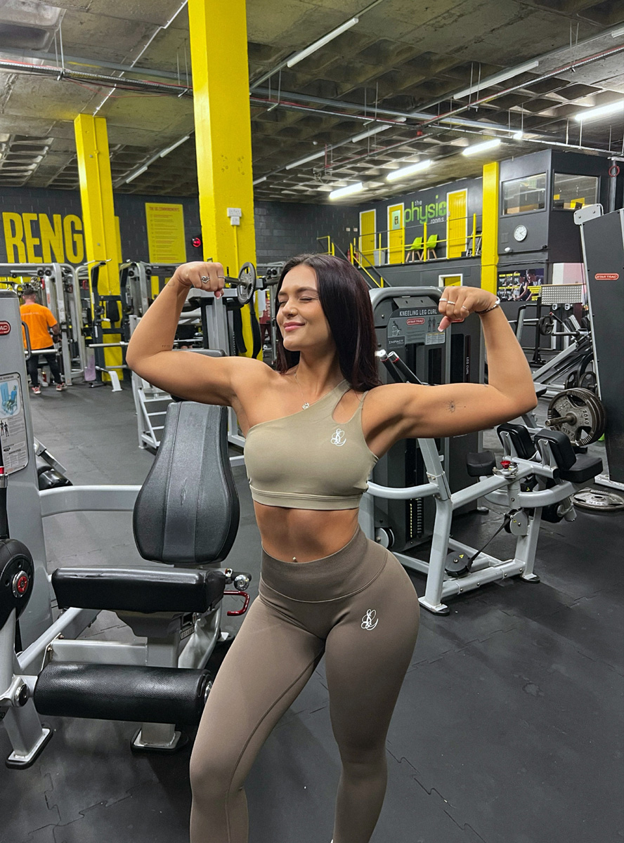 The coach is posing at the gym.